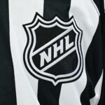 https://predictionpro.com/uncategorized/auto-draft Pictured: View of an NHL logo on a jersey worn by a linesman.